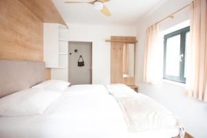 1 dormitorio con cama blanca y ventana en Hotel Modus, en Salzburgo