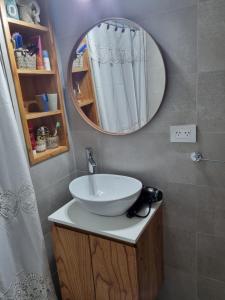 Elegante 3 dormitorios في بوينس آيرس: حمام مع حوض ومرآة