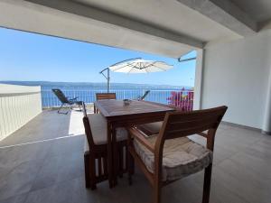 a dining room with a table and chairs on a balcony at Apartments Timee first row to beach in Stanići