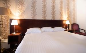 ウェストン・スーパー・メアにあるCabot Court Hotel Wetherspoonのベッドルーム(白い枕の大型ベッド1台付)