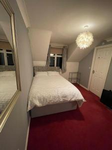 a bedroom with a large bed and a chandelier at Room 5 - Chassagne Guest House in Church Coppenhall