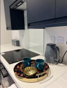 a tray with two cups on a kitchen counter at Studios 21- By Eazy Rooms in Hessle