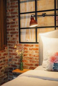a bedroom with a bed and a lamp on a table at 36 Phô Cô Hotel & Suites in Weimar
