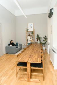a wooden table in a living room with a woman on a couch at Jupiter Home Buda in Budapest
