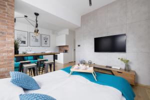 Turquoise Studio with Balcony & Air Conditioning Kraków by Renters في كراكوف: غرفة نوم مع سرير وغرفة معيشة