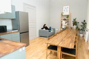 a living room with a table and two people sitting on a couch at Jupiter Home Buda in Budapest