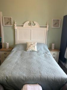 a bedroom with a large bed with a white headboard at Glan Y Mor Hotel (Adult Only) in Llandudno