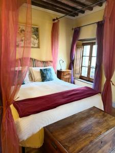a bedroom with a large bed with pink curtains at Pienzalettings in Pienza