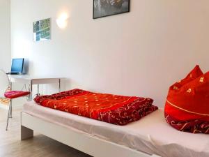 Schlafzimmer mit einem Bett mit roter Bettwäsche und einem Schreibtisch in der Unterkunft Herberge Zum Steiger Franz in Sedlitz