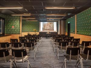 ein leeres Zimmer mit Stühlen und einer Leinwand in der Unterkunft Eklo Paris Expo Porte de Versailles in Vanves