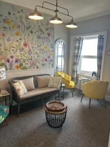a living room with a couch and a flowery wall at Glan Y Mor Hotel (Adult Only) in Llandudno