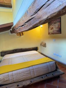 a bed in a room with a wooden ceiling at Pienzalettings in Pienza