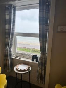 a window with a table and a stool in front of it at Glan Y Mor Hotel (Adult Only) in Llandudno