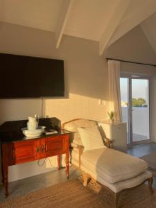 a living room with a table and a tv at Bougain Villa Studio 2 in Paternoster