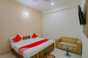 a small bedroom with a bed and a couch at OYO Flagship Hotel Soho in Noida