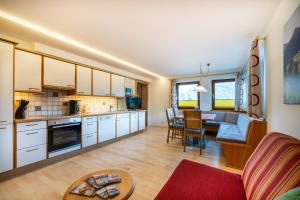 a kitchen and living room with a couch and a table at Rickys Apartment Flachau in Flachau