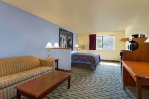 a hotel room with a couch and a bed at Super 8 by Wyndham Lynchburg VA in Lynchburg