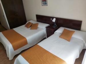 dos camas sentadas una al lado de la otra en una habitación en Hotel Complutense, en Alcalá de Henares