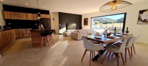 een keuken en een woonkamer met een tafel en stoelen bij Élégance Corse : Maison 3 chambres, Piscine in Figari