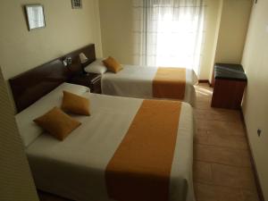 pokój hotelowy z 2 łóżkami i oknem w obiekcie Hotel Complutense w mieście Alcalá de Henares