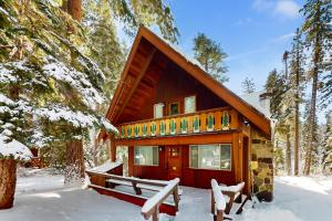 una cabaña de madera en la nieve con bancos delante en Ward Creekside Cabin, en Tahoe City