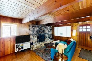 ein Wohnzimmer mit einem blauen Sofa und einem Steinkamin in der Unterkunft Ward Creekside Cabin in Tahoe City
