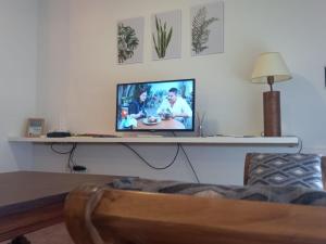 a television sitting on a table in a living room at Departamento dos dormitorios con cochera Tres Arroyos -3- in Tres Arroyos