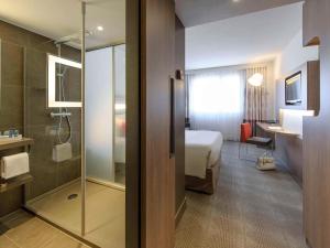 a hotel room with a bed and a bathroom at Novotel Lugano Paradiso in Lugano