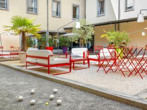 a group of chairs and tables in front of a building at ibis Lyon Sud Vienne Saint-Louis in Vienne