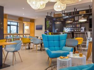 un restaurante con mesas y sillas azules y un bar en ibis Lyon Sud Vienne Saint-Louis, en Vienne