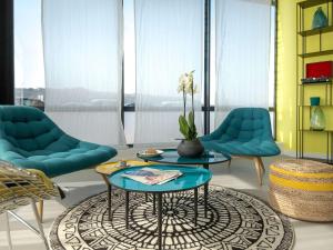 een woonkamer met twee blauwe stoelen en een tafel bij ibis Lyon Sud Vienne Saint-Louis in Vienne