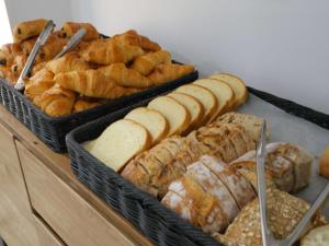 ein paar verschiedene Brotsorten und Gebäck in der Unterkunft ibis Styles Saint Julien en Genevois Vitam in Neydens