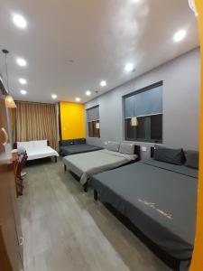 a room with two beds and a table in it at Thanh Hằng Homestay in Can Tho