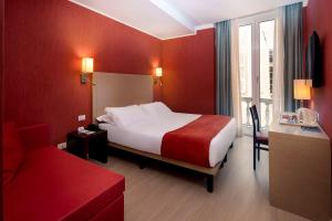 une chambre d'hôtel avec un lit et un mur rouge dans l'établissement Best Western Porto Antico, à Gênes