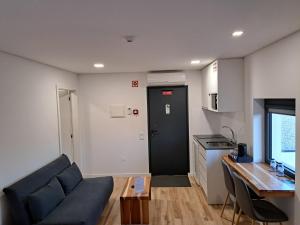 ein Wohnzimmer mit einem Sofa und einem Tisch sowie eine Küche in der Unterkunft Agrafonte in Paços de Ferreira