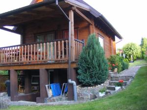 a log cabin with a porch and a deck at Dom letniskowy ANTOLEK in Ryn