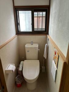 a small bathroom with a toilet and a window at 高知県　みどりの家 in Gomen