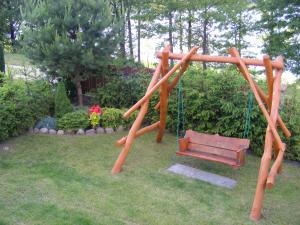 a playground with a swing and a bench at Dom letniskowy ANTOLEK in Ryn