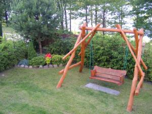 a playground with a swing and a bench at Dom letniskowy ANTOLEK in Ryn +1 photo