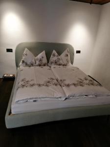 a bed with white sheets and pillows on it at Altstadt Apartment Melk in Melk