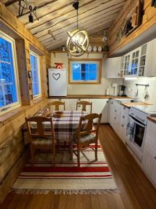 a kitchen with a table and chairs in a cabin at Cozy cabin HYLLA in Hamnvågnes