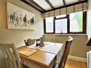 a dining room with a wooden table and a window at 1 Bed in Exmoor National Park 89766 in Parracombe