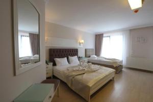 a hotel room with two beds and a mirror at Blue Pier Hotel in Kocaeli