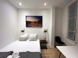 パリにある64-ラグジュアリー フラット シャンゼリゼ（1D）の白いベッドルーム(ベッド1台、テーブル付)