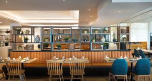 a dining room with tables and blue chairs at Valamar Diamant Hotel in Poreč