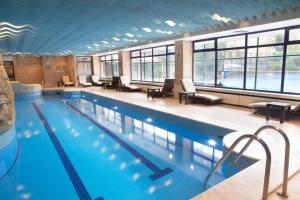 a large swimming pool in a building with chairs at Hilton Istanbul Bosphorus in Istanbul