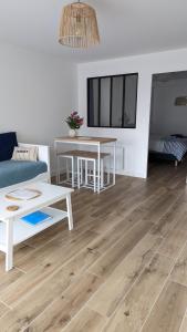 a living room with a couch and a table at L'Échappée Bleue, vue mer in Binic