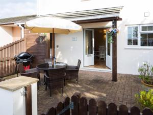 a patio with an umbrella and a table and chairs at 2 Bed in Westward Ho 73857 in Westward Ho