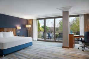 una camera d'albergo con letto, scrivania e balcone di Hilton Istanbul Bosphorus a Istanbul