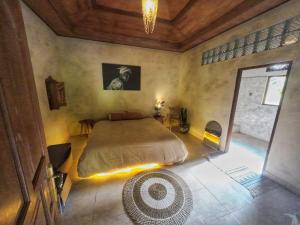 D'Sari Undisan Houses - Abeona Private Villa في Undisan: غرفة نوم بها سرير كبير مع إضاءة